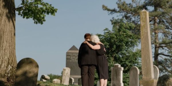 Mother and son dressed in black at a funeral